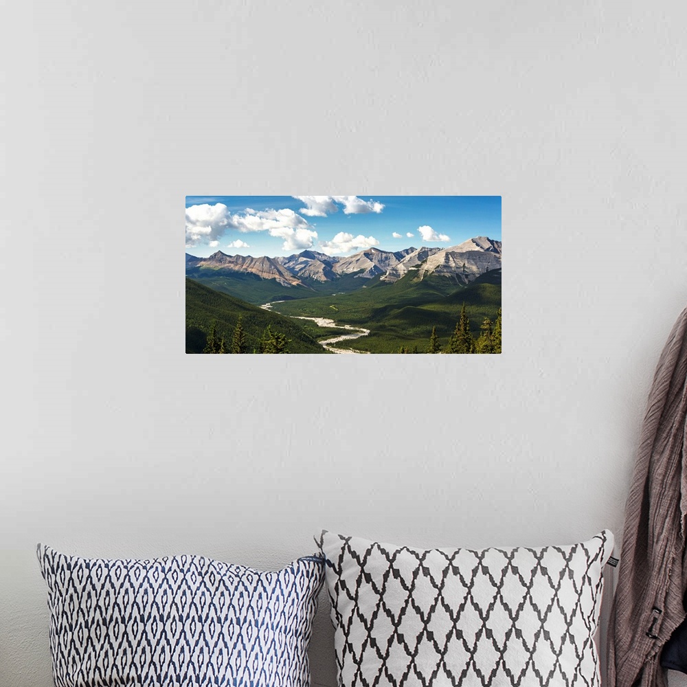 A bohemian room featuring Panorama of river valley and mountain range with blue sky and clouds, Bragg Creek, Alberta, Canada.