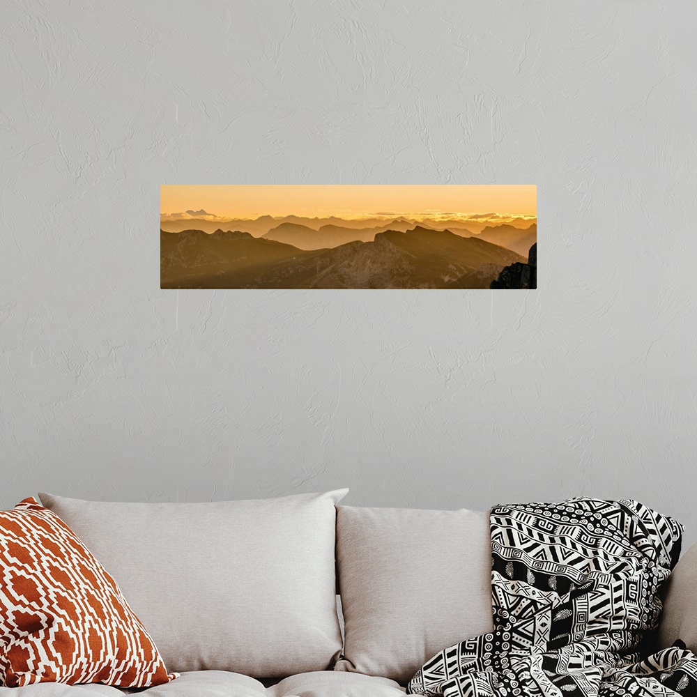 A bohemian room featuring Golden landscape photograph of snowy mountain tops going back into the distance as far as you can...