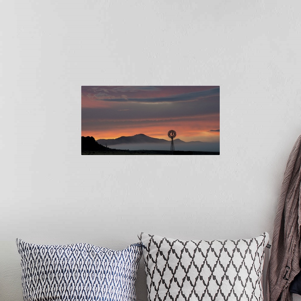 A bohemian room featuring A photograph of mountains cast in shadow from the light of the setting sun.
