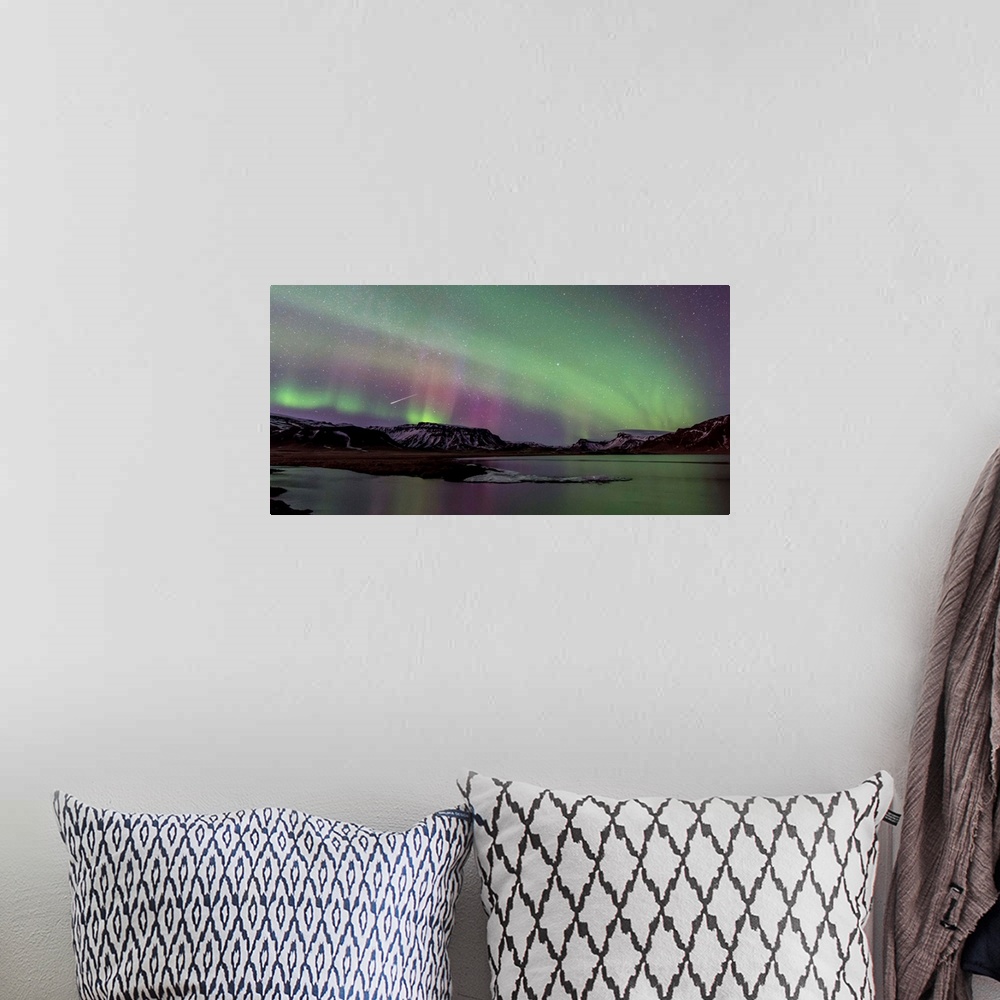 A bohemian room featuring Long exposure photograph of the Northern Lights over snow covered mountains and a lake.