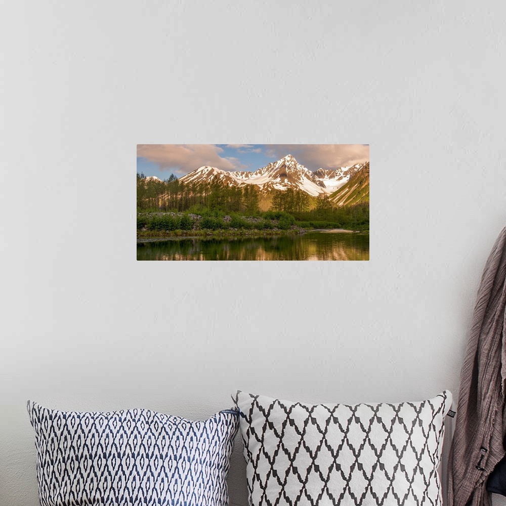 A bohemian room featuring Landscape photograph of a lake in front of snowy mountain peaks with warm lighting.