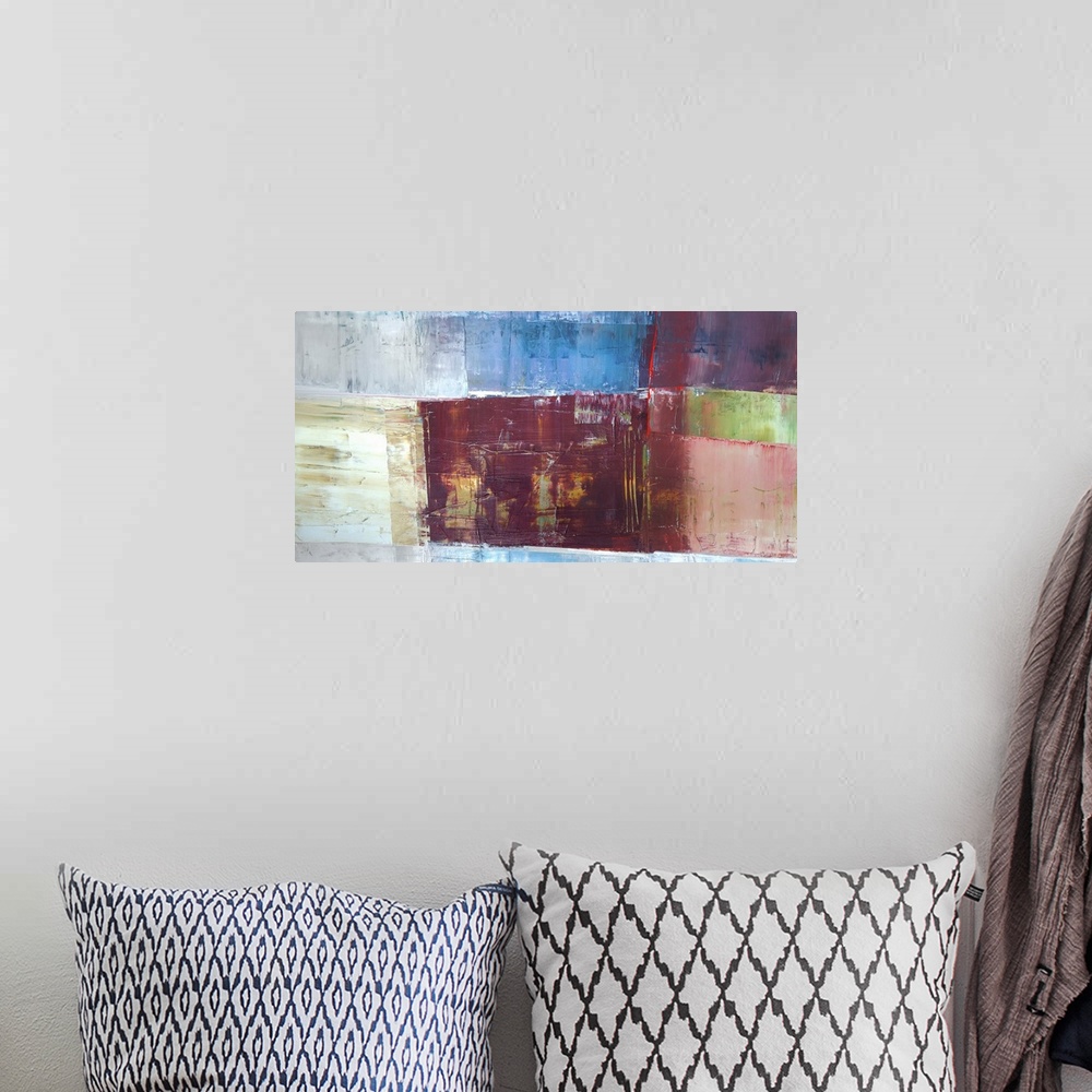 A bohemian room featuring A horizontal abstract painting in textured colors of brown, blue and red in box shapes.