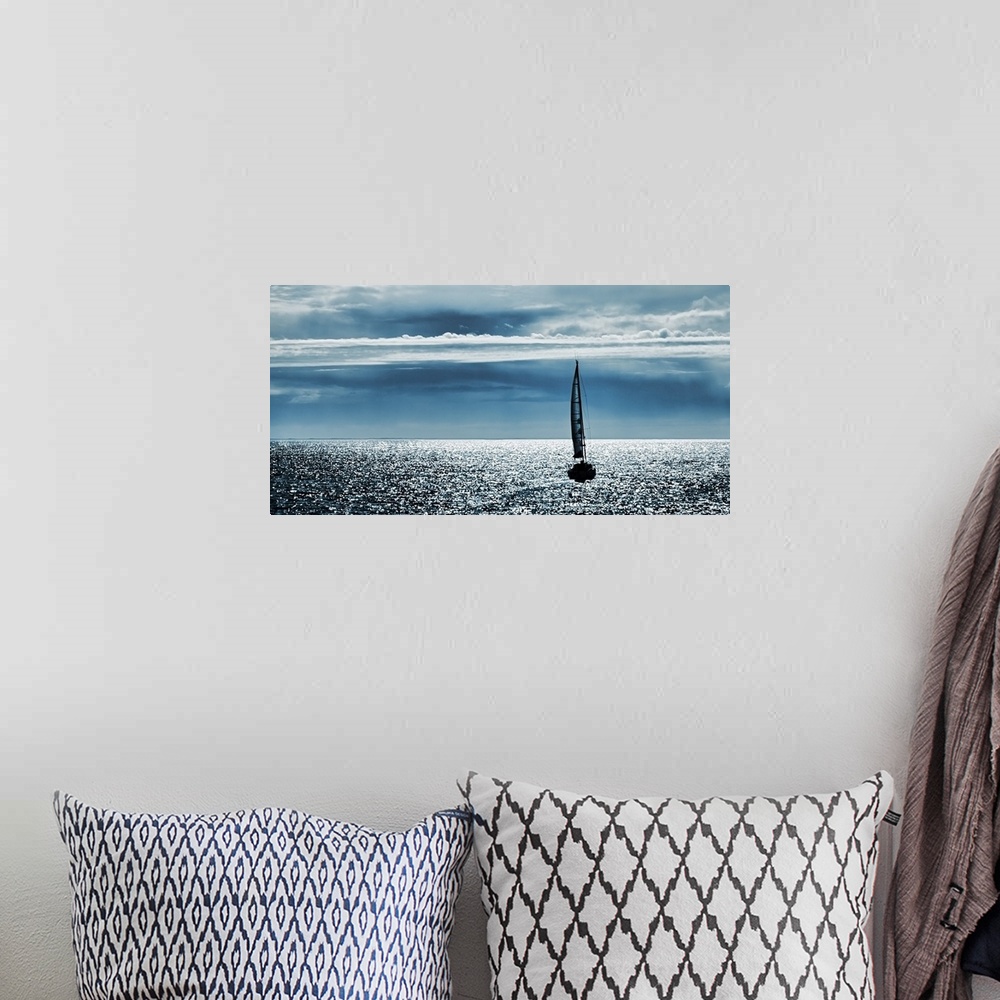 A bohemian room featuring Silhouettes of a yacht sailing alone in the ocean to the horizon.