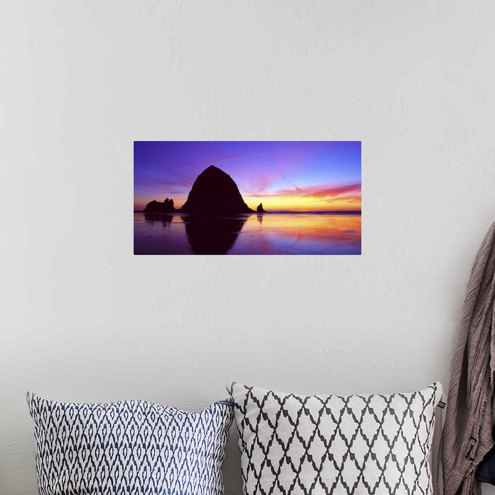 A bohemian room featuring Sea stacks on the beach silhouetted at sunset, Cannon Beach, Oregon.