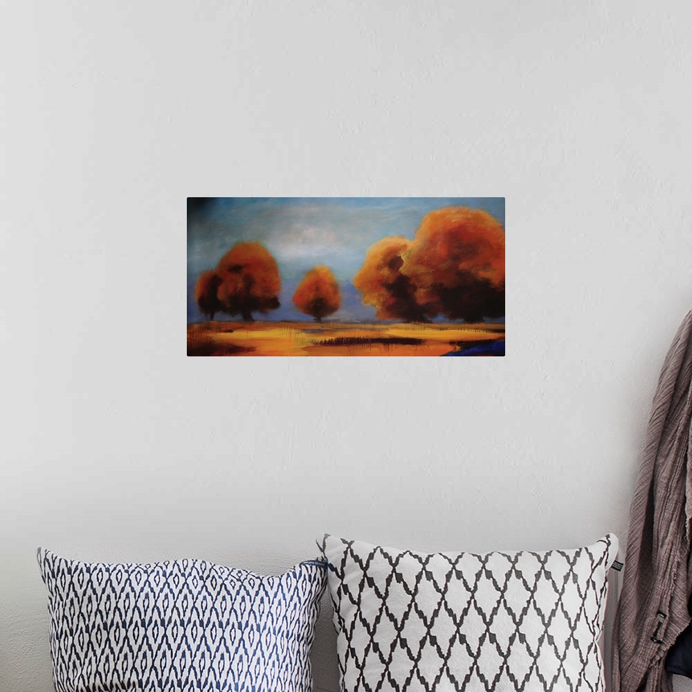 A bohemian room featuring Contemporary artwork of brightly colored fall trees against a shaded blue sky.