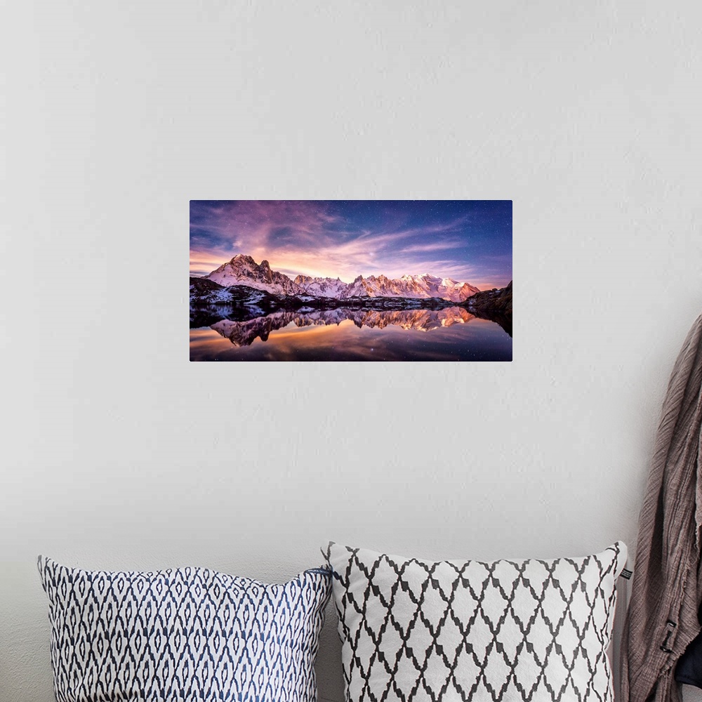A bohemian room featuring Fine art photograph of a snowy mountain range reflected in the water under a lavender sky in France.