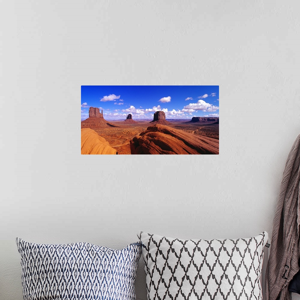 A bohemian room featuring Large panoramic photograph taken of Monument Valley with giant rock formations seen in the distan...