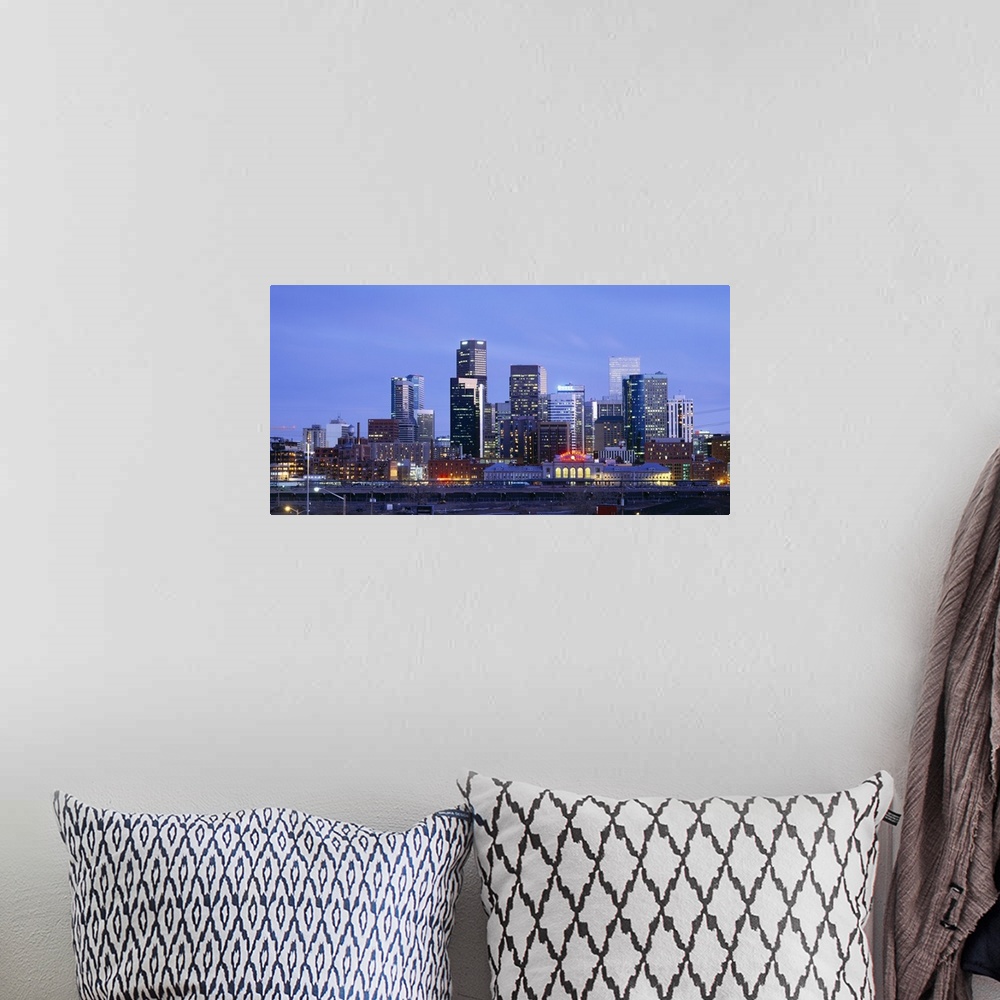 A bohemian room featuring A large panoramic piece of a photograph of the Denver skyline with the buildings lit up during su...