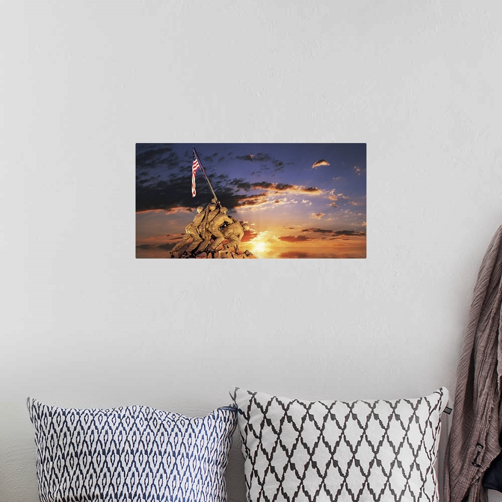 A bohemian room featuring Composite image of a statue of American soldiers raising a flag on a rocky mount and the sun sett...