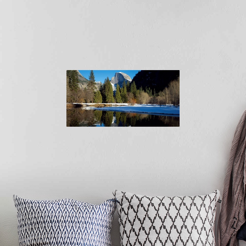 A bohemian room featuring This picture is taken of Yosemite during winter with trees lining the water and a view of a mount...