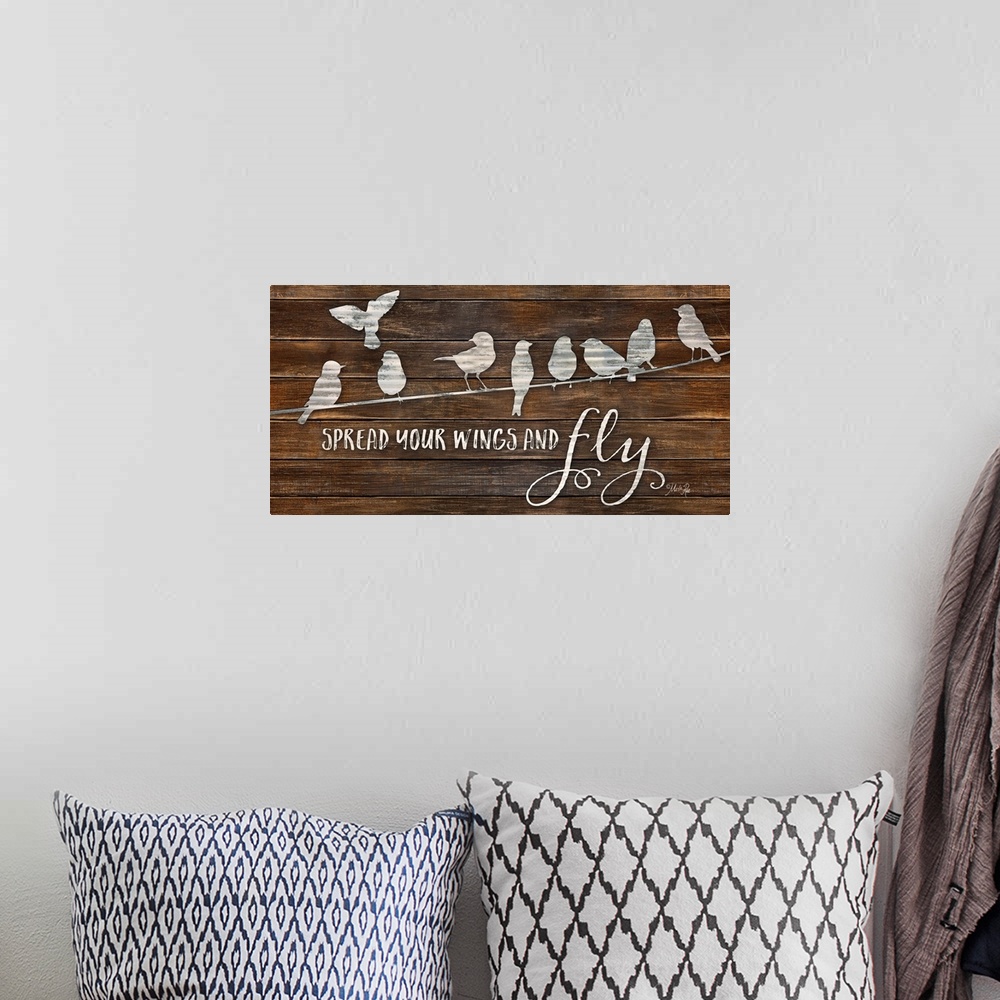 A bohemian room featuring "Spread Your Wings and Fly" with a design of birds on a line on a brown wood plank background.