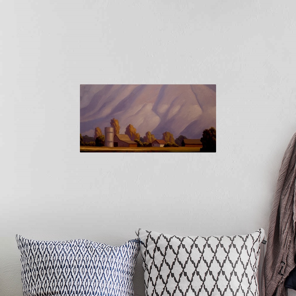A bohemian room featuring Landscape painting of a farm with mountains in the background.