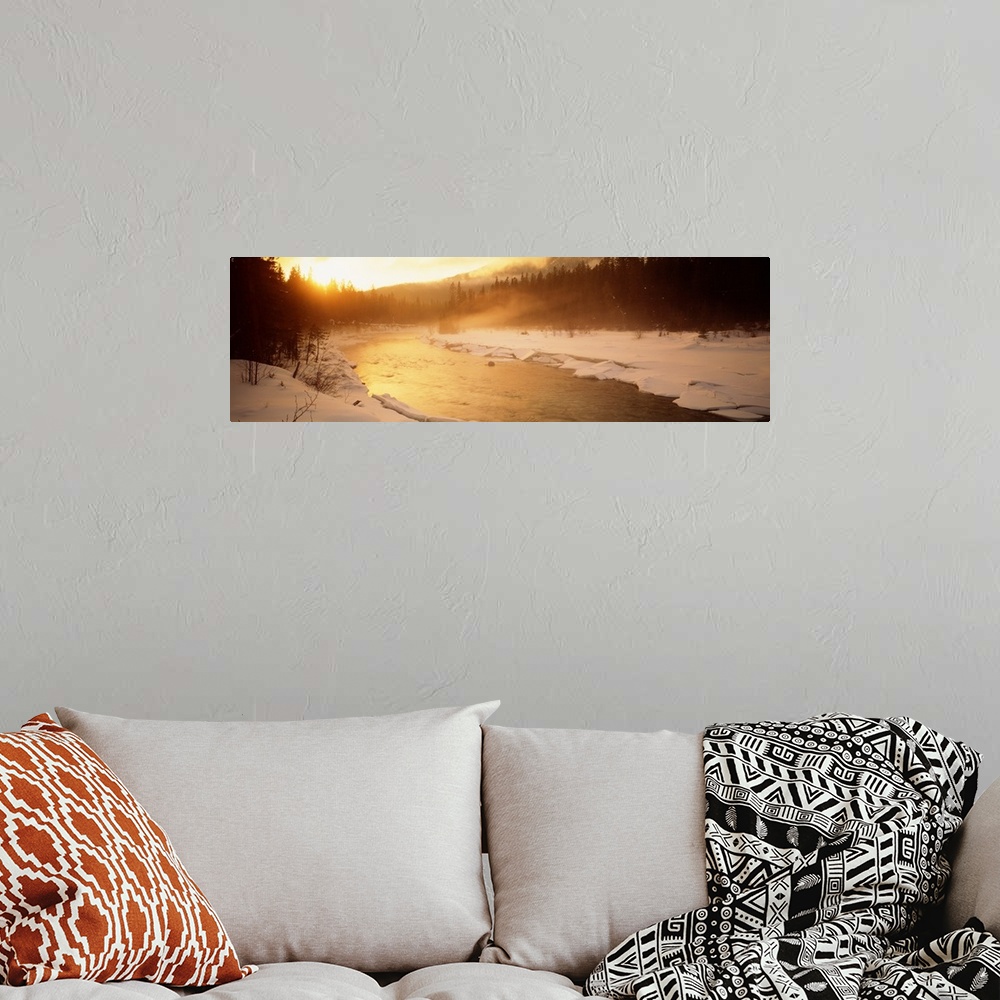 A bohemian room featuring Panoramic image of a river running through a frozen landscape with fog coming off it and warm sun...