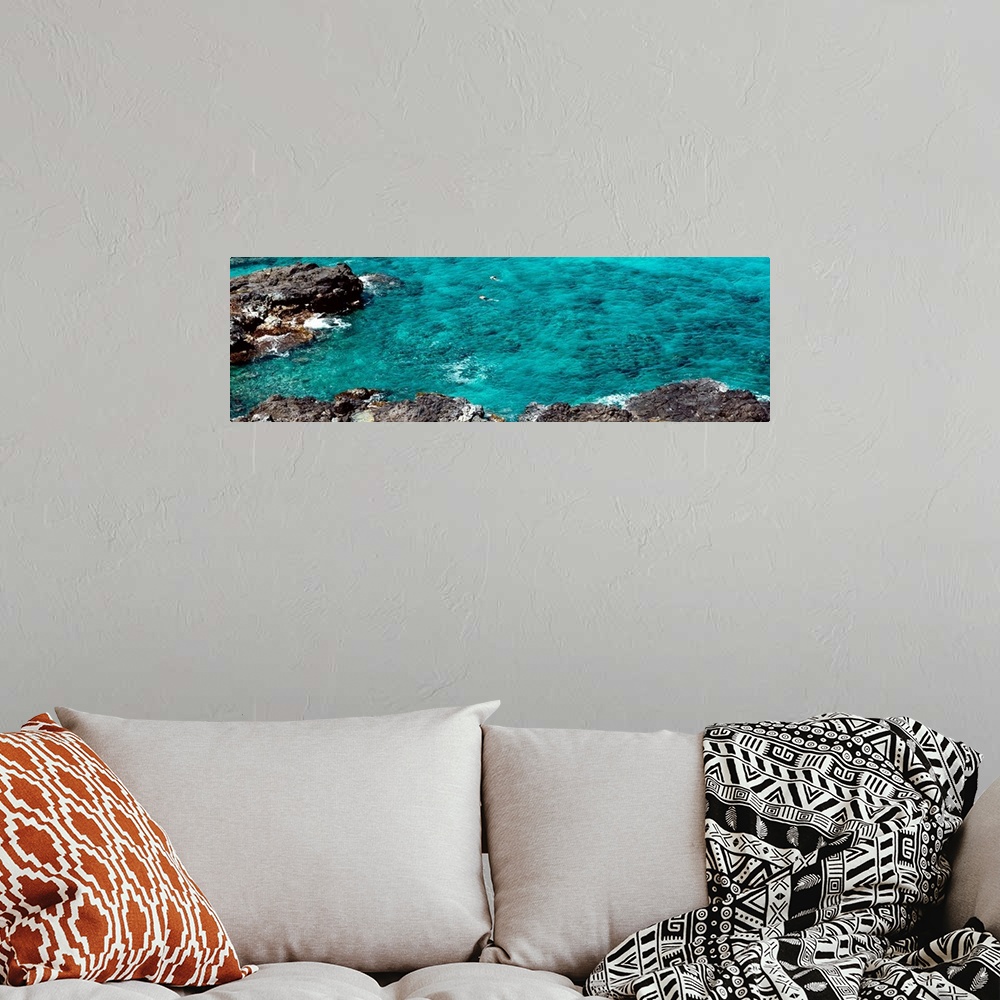 A bohemian room featuring This panoramic photograph shows two figures from distance in clear waters of a reef.