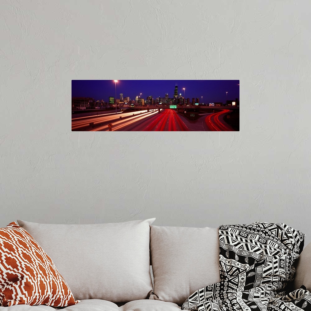 A bohemian room featuring Panoramic photograph of highway filled with light trails with lit up city skyline in the distance...
