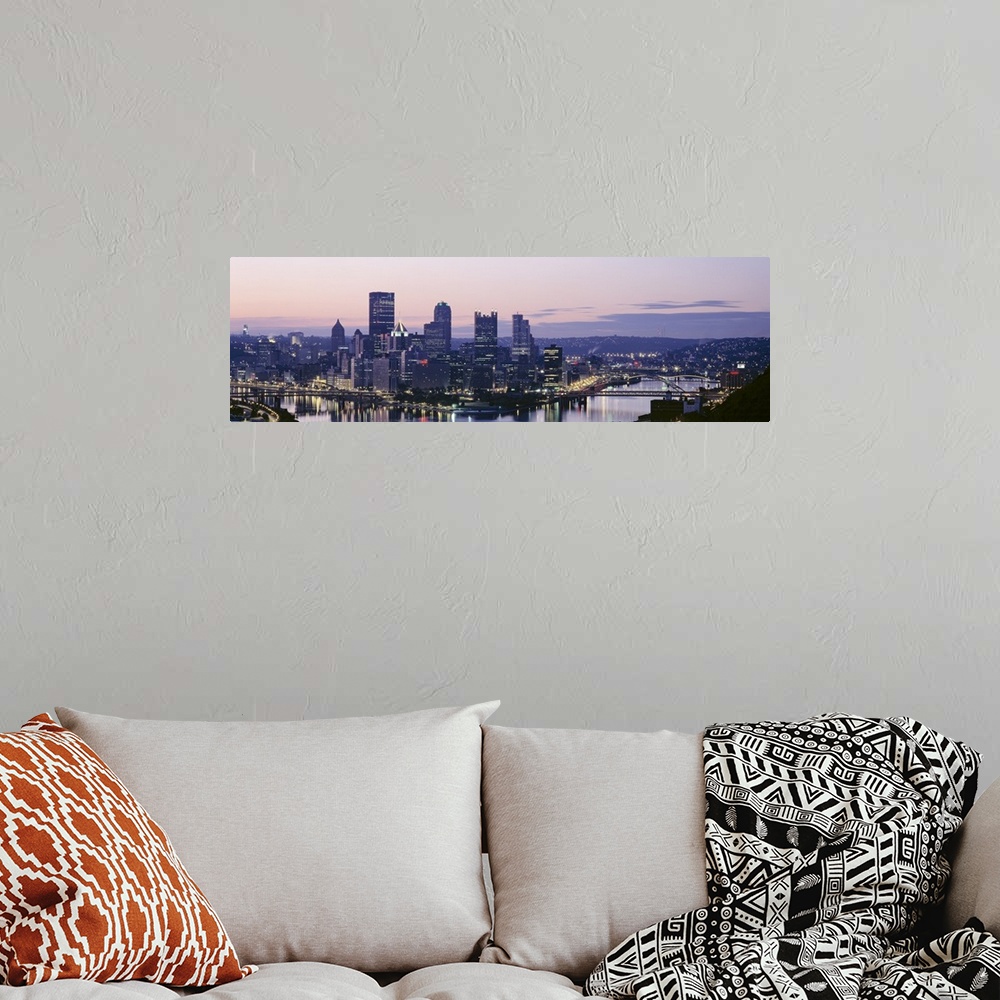 A bohemian room featuring Panoramic photograph of skyline and waterfront lit up at sunset.
