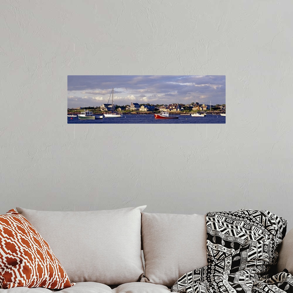 A bohemian room featuring Large landscape photograph of many boast in Sakonnet Harbor, houses line the landscape, beneath a...