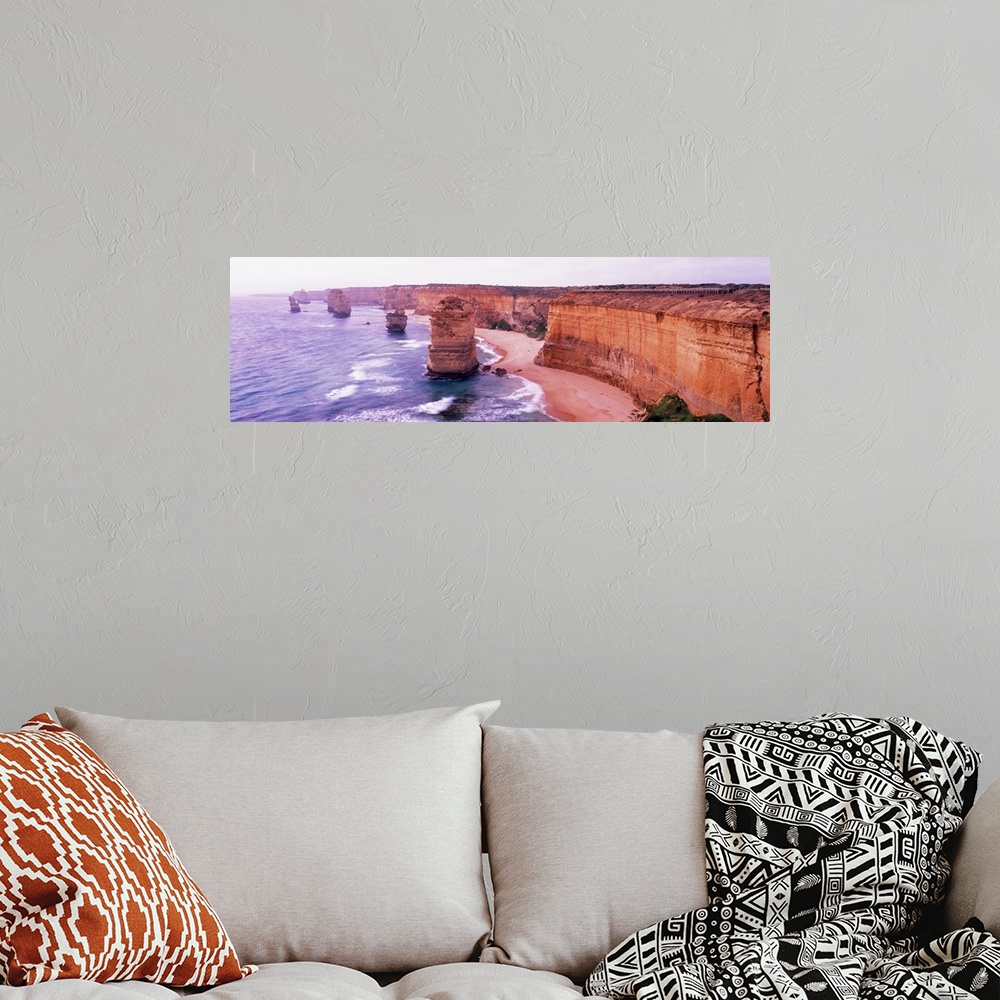 A bohemian room featuring Pano of the Twelve Apostles sticking out of the Tasman Sea as the waves crash on to the sandy sho...