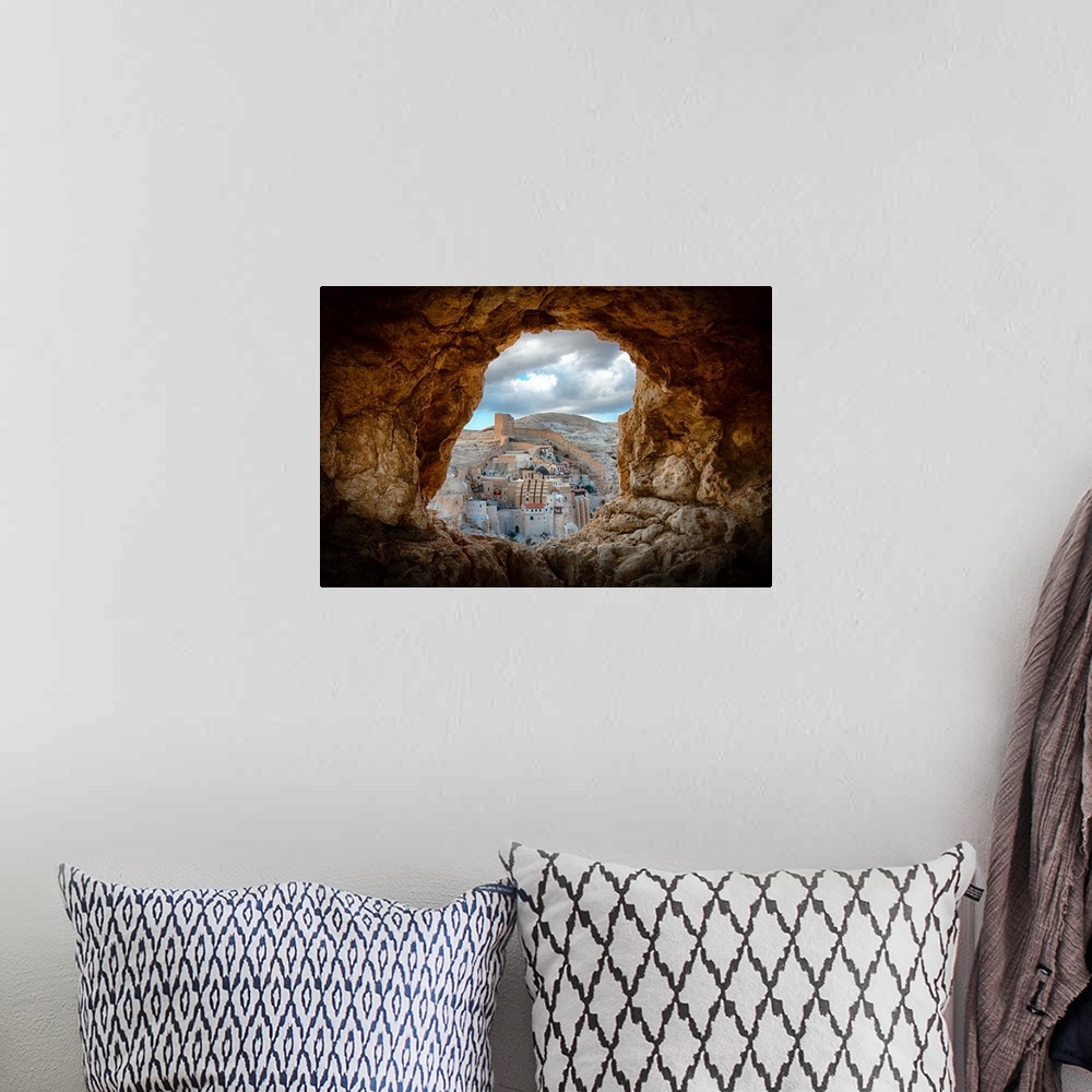 A bohemian room featuring View of Mar Saba Monastery in Israel from a hole in a rocky wall.