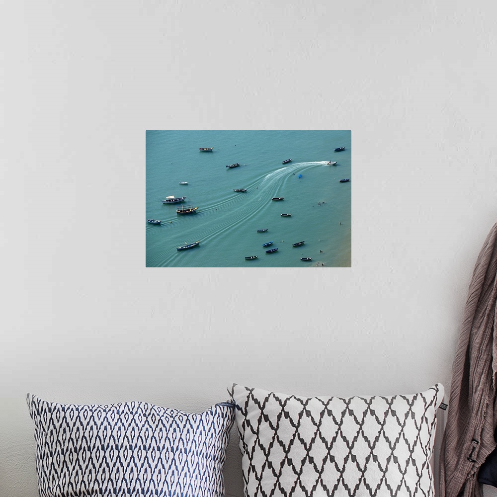 A bohemian room featuring Aerial photograph of boats anchored on a teal ocean with wave lines creating movement from one mo...