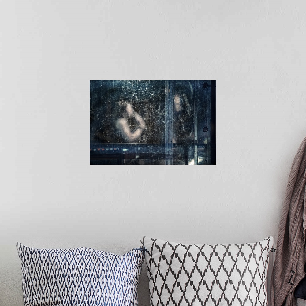 A bohemian room featuring An abstract photograph of a figure behind a blue dirty and scratched screen.