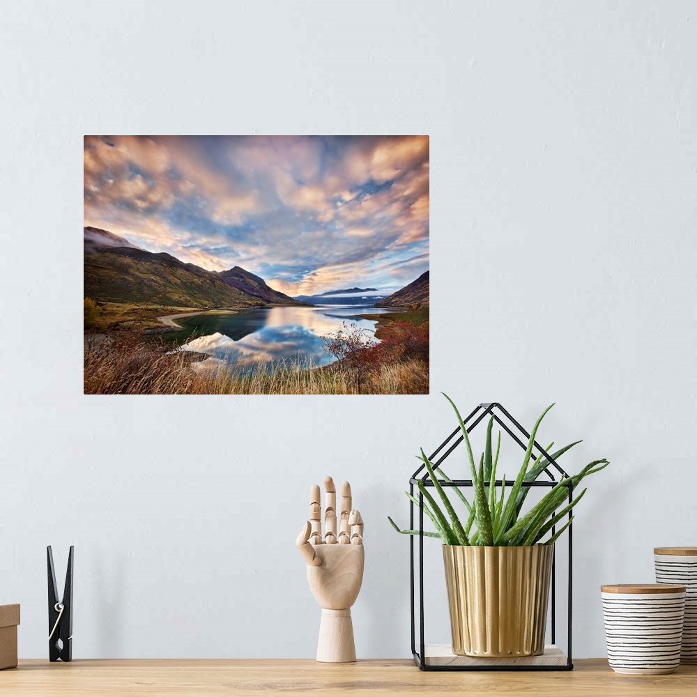 A bohemian room featuring Dramatic clouds hang over a mountain lake scene.
