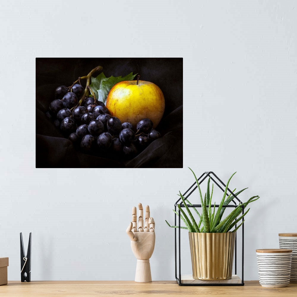 A bohemian room featuring Fine art still life photo of bunch of dark red grapes and a golden apple.