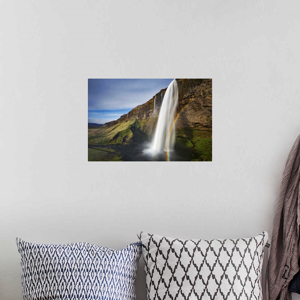 A bohemian room featuring A waterfall in a cliff with a rainbow, Seljalandsfoss, Iceland.