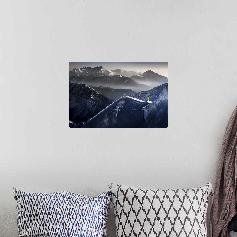 A bohemian room featuring A skier pauses at the top of a mountain, with peaks of neighboring mountains in the background.