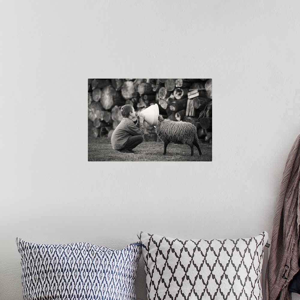 A bohemian room featuring A black and white photograph of a child talking into funnel with a sheep poking its head into the...