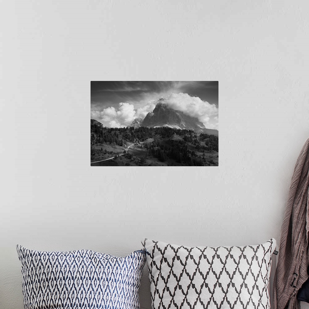 A bohemian room featuring A giant cloud passes over a mountaintop, resembling billowing smoke.