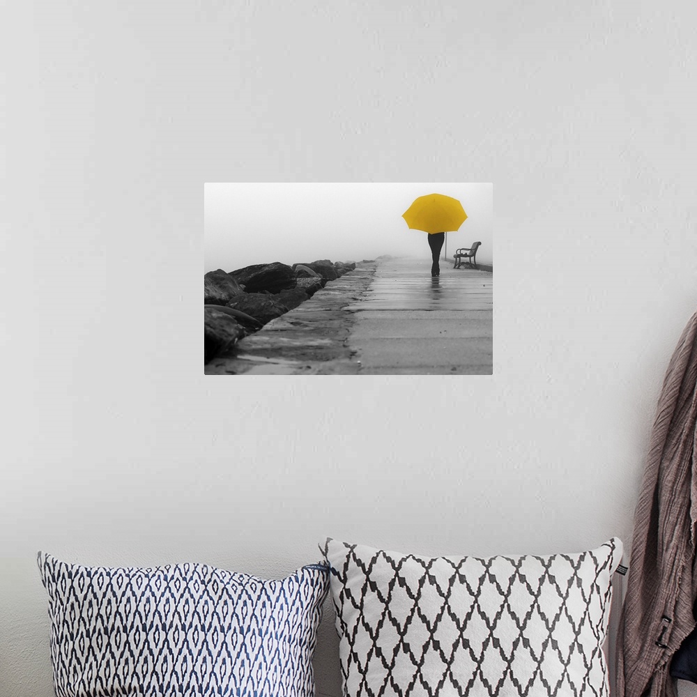 A bohemian room featuring A black and white photograph of a person with a colorized yellow umbrella sitting on a bench on a...