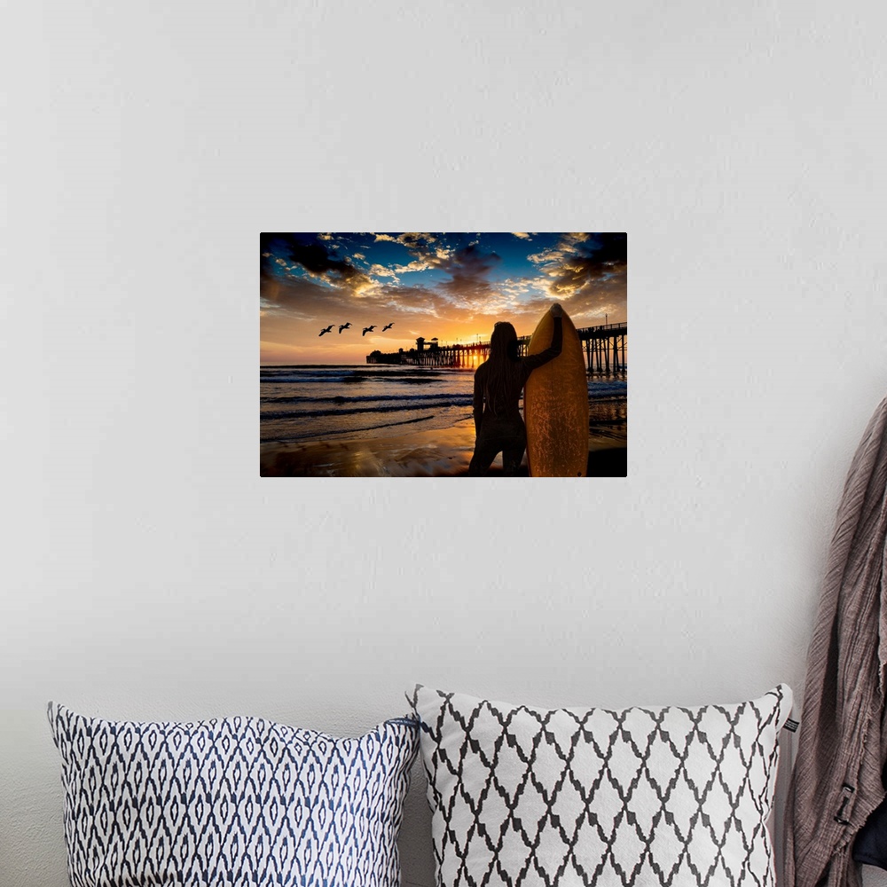 A bohemian room featuring A female surfer watches the last waves near the Oceanside Pier, Oceanside, California, USA