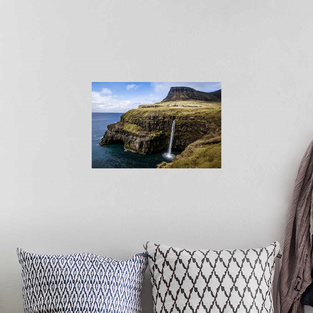 A bohemian room featuring A waterfall cascades down a dramatic rockface on the Faroe Islands.