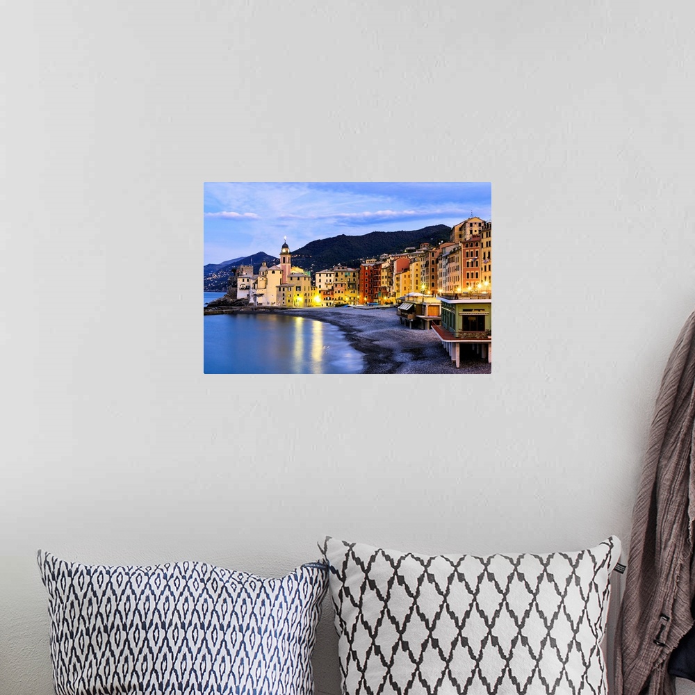 A bohemian room featuring Buildings illuminated by lights along the water's edge at sunrise, Camogli, Liguria, Italy.