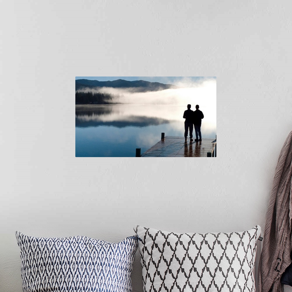 A bohemian room featuring Couple standing on a dock and silhoutted against the fog lifting from Lake Whatcom during Winter,...