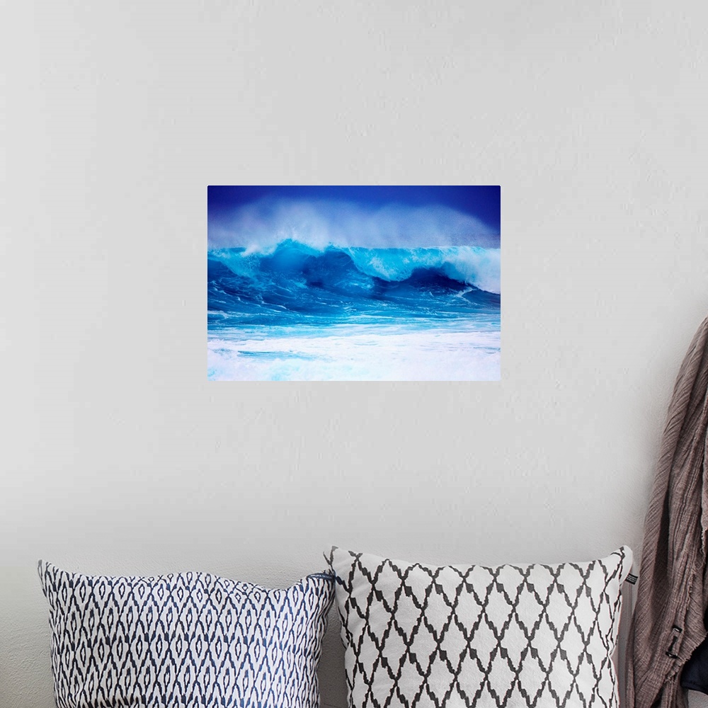 A bohemian room featuring Giant horizontal photograph of a vibrant blue wave spraying upward as it begins to crash onto its...