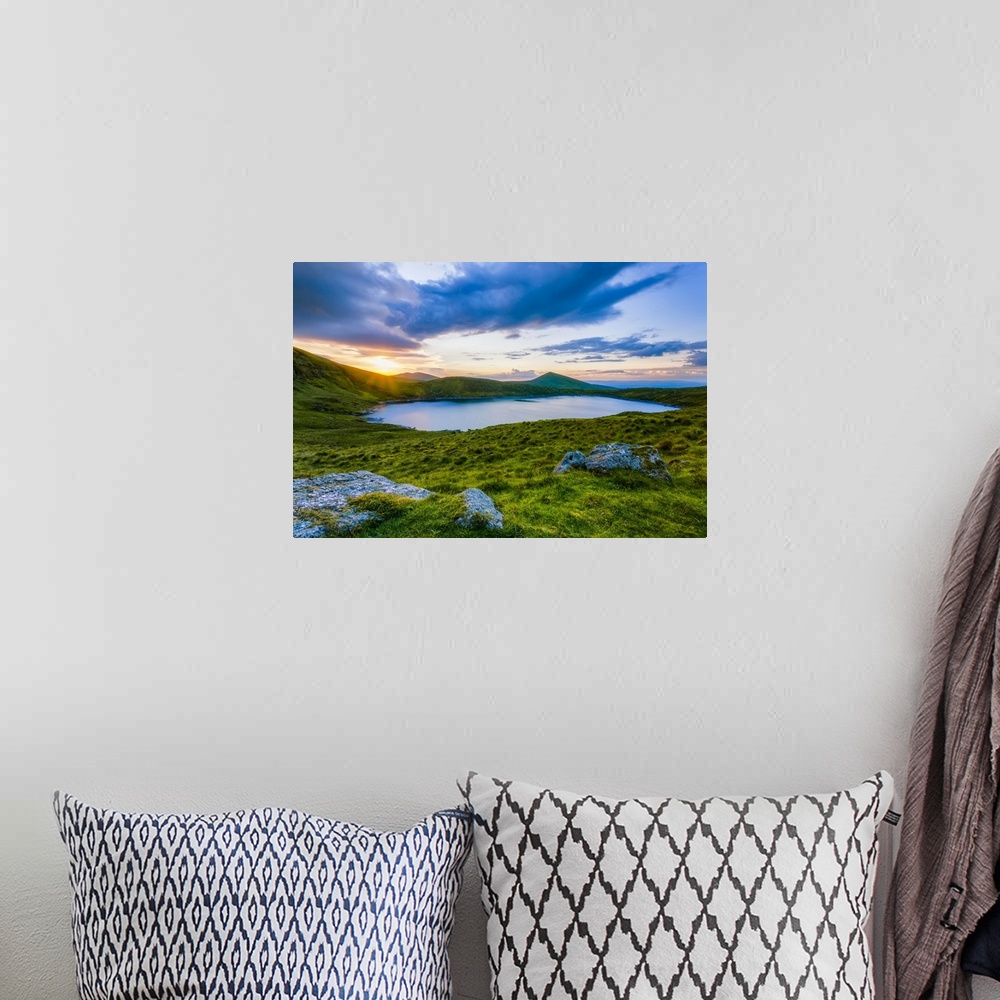 A bohemian room featuring Sun setting over Lough Muskery in the Galty Mountains in summer with large boulders in the foregr...
