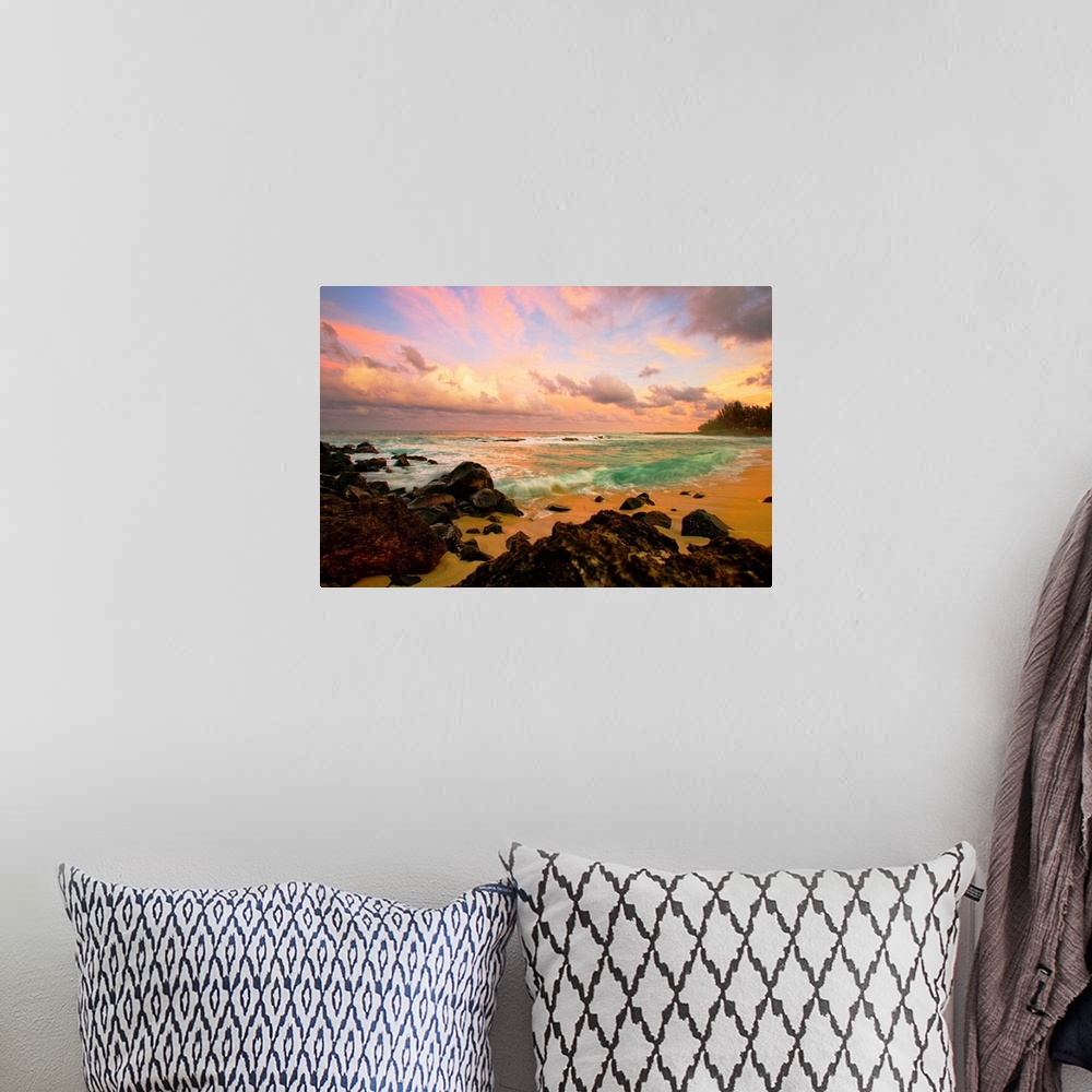 A bohemian room featuring Photograph taken over rocks that line a beach and looking out onto a sunset lit sky.