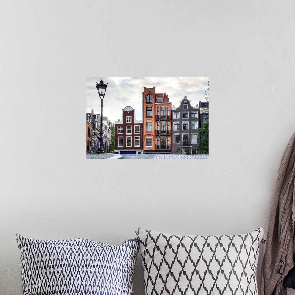 A bohemian room featuring Unique residential buildings and a lamp post; Amsterdam, Netherlands