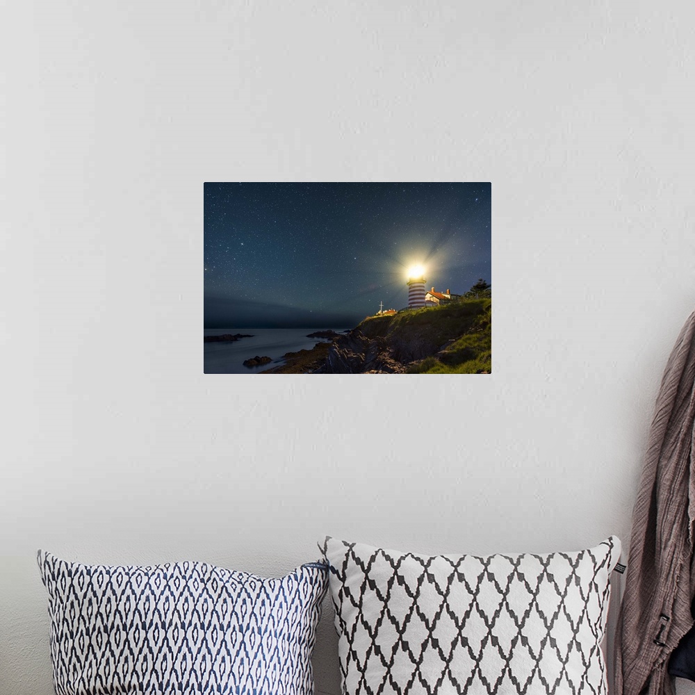 A bohemian room featuring A photograph of a lighthouse under a starry night sky.