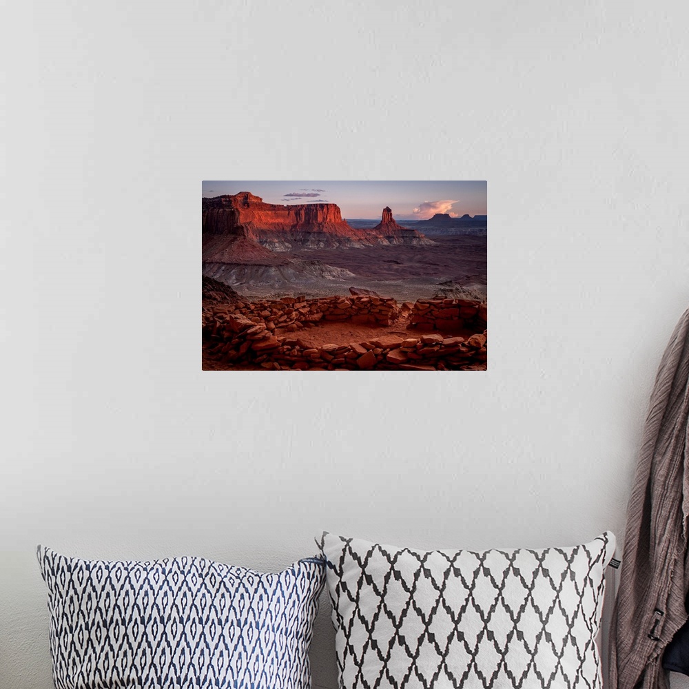 A bohemian room featuring Landscape photograph of stacked rocks creating a circle with canyons in the background at sunrise.