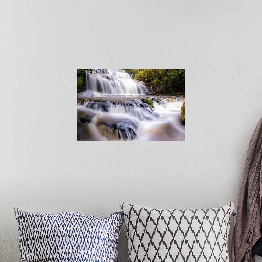 A bohemian room featuring Long exposure photograph of a rushing waterfall surrounded by lush green foliage.