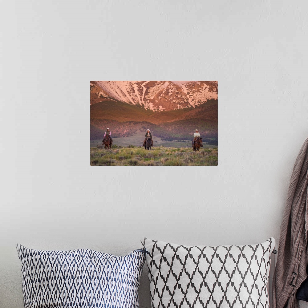 A bohemian room featuring Photograph of three people on horseback in a row with snow covered mountains in the background.