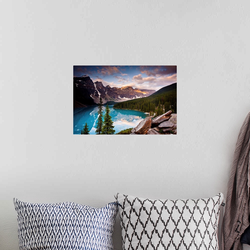 A bohemian room featuring Landscape photograph of Lake Moraine surrounded bu snowy mountains and pine trees.