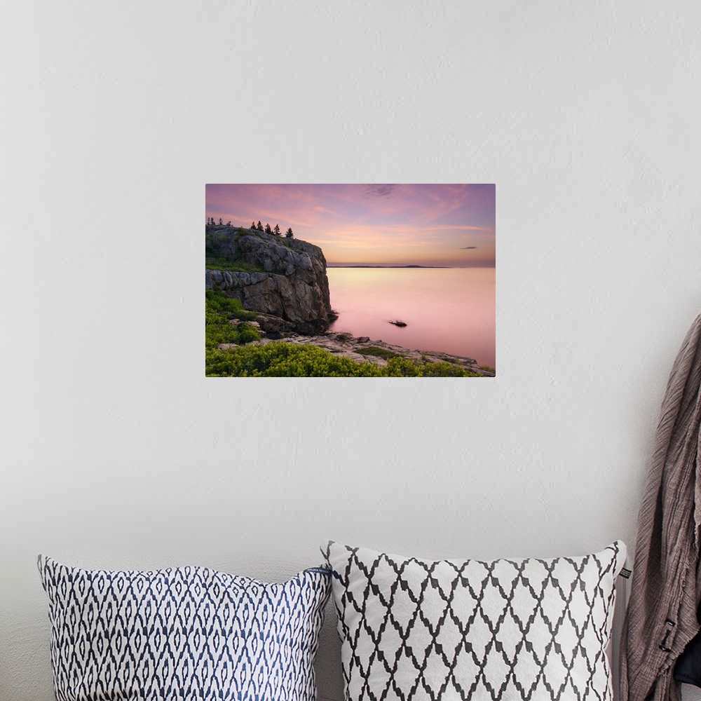 A bohemian room featuring An artistic photograph of a rocky cliff-side overlooking a sunset drenched seascape.