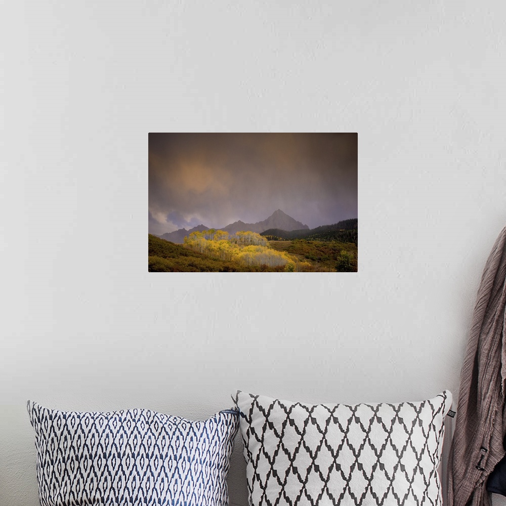 A bohemian room featuring A photograph of a mountain landscape with hazy clouds hanging overhead.