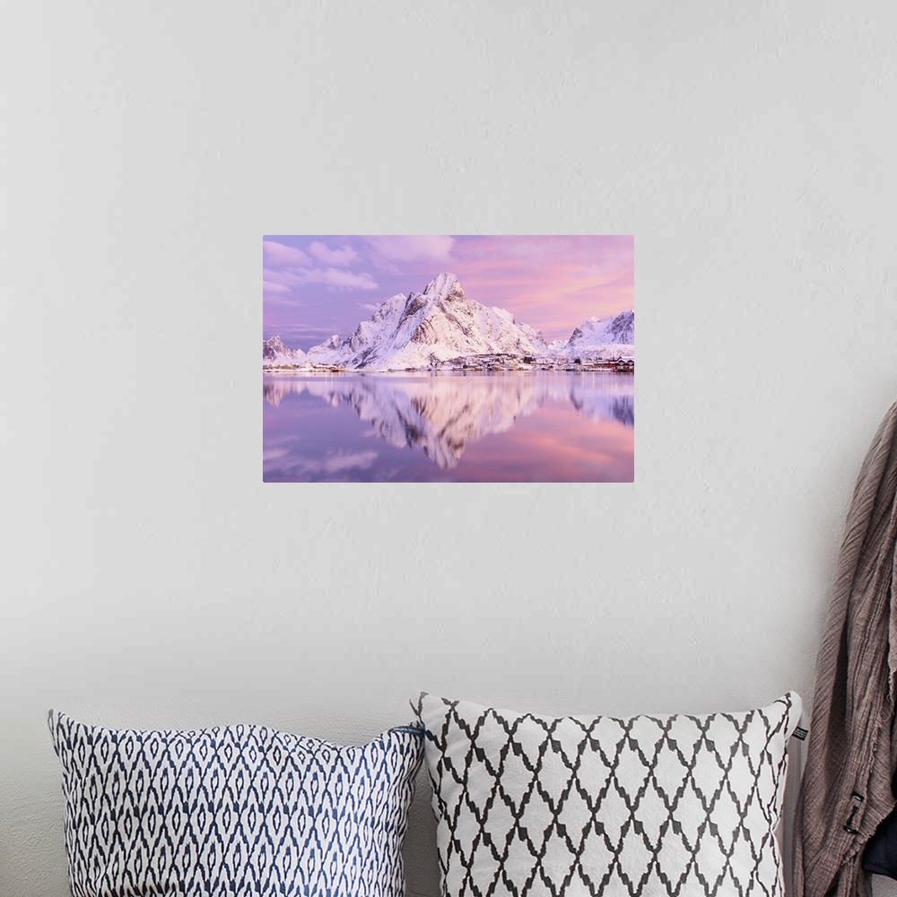A bohemian room featuring A photograph of a snow covered mountain range in winter casting a clear reflection in the fjord b...