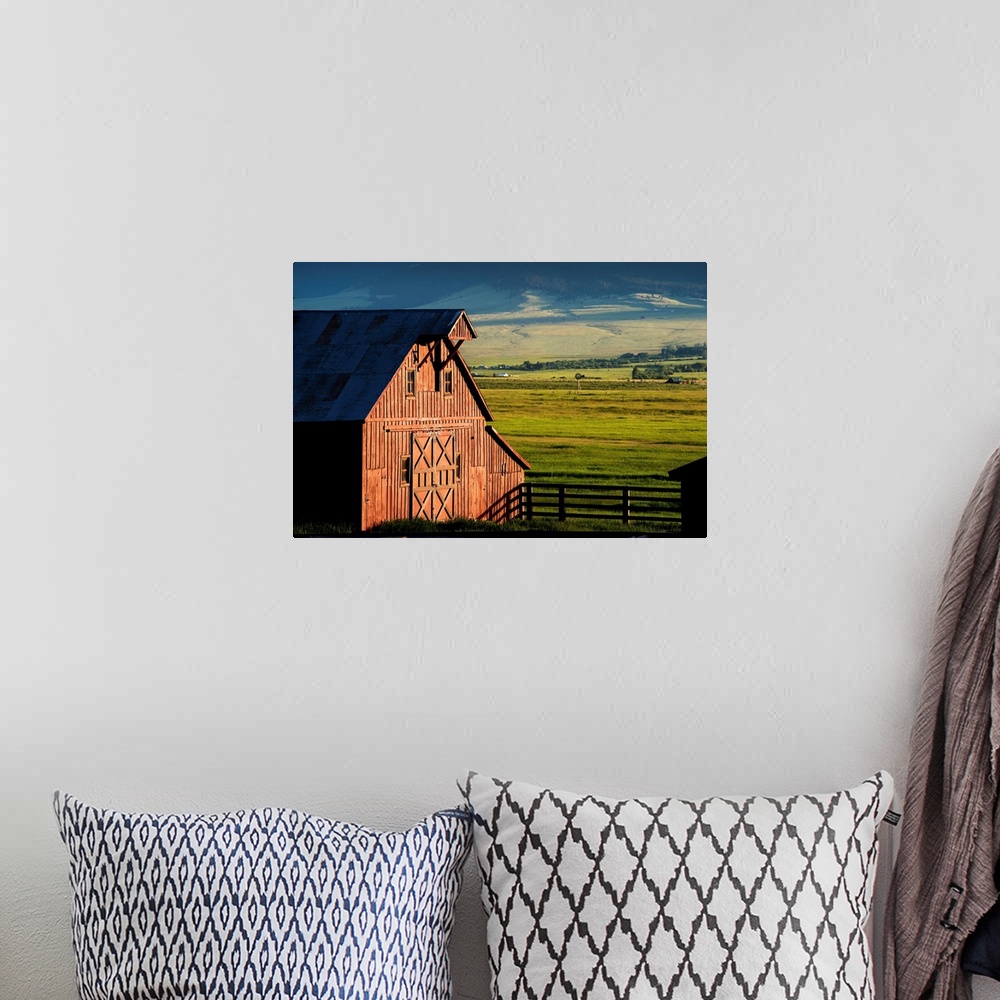 A bohemian room featuring Photograph of a red barn with green farmland in the background.