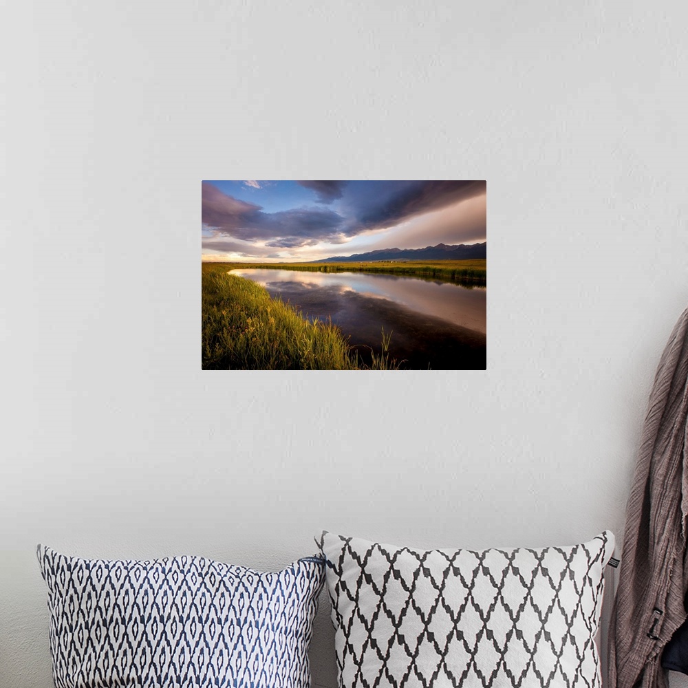A bohemian room featuring Landscape photograph of a river in the valley reflecting the cloudy sky.